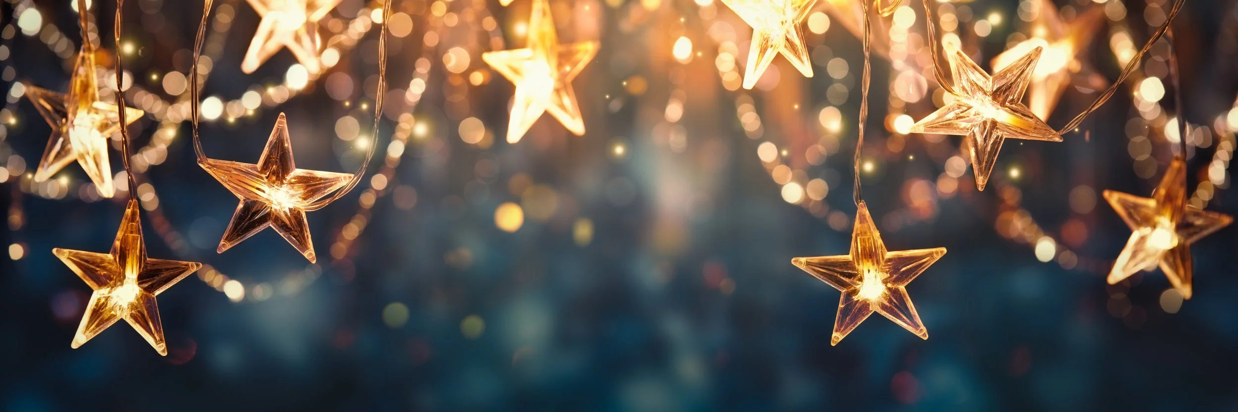 String of illuminated star-shaped string lights with a warm glow, against a blurred background of golden bokeh.