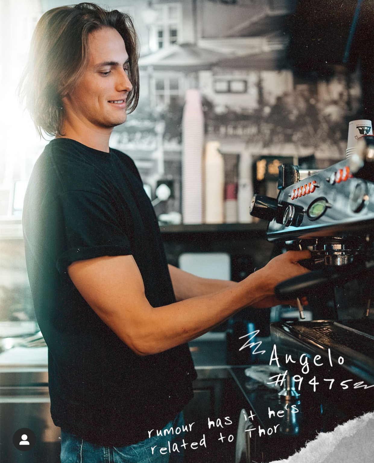 A young man with shoulder-length hair making coffee behind a commercial espresso machine in a cafe.
