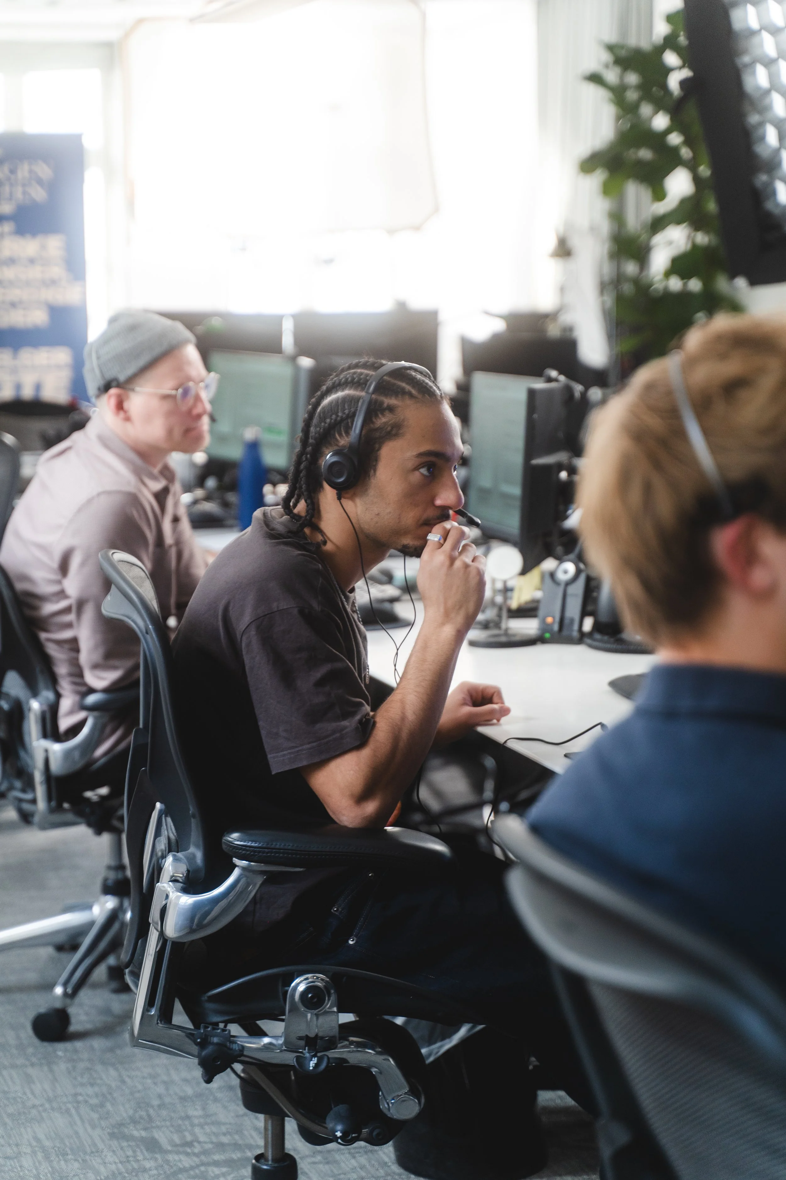 Group of people working at computers in an office environment.