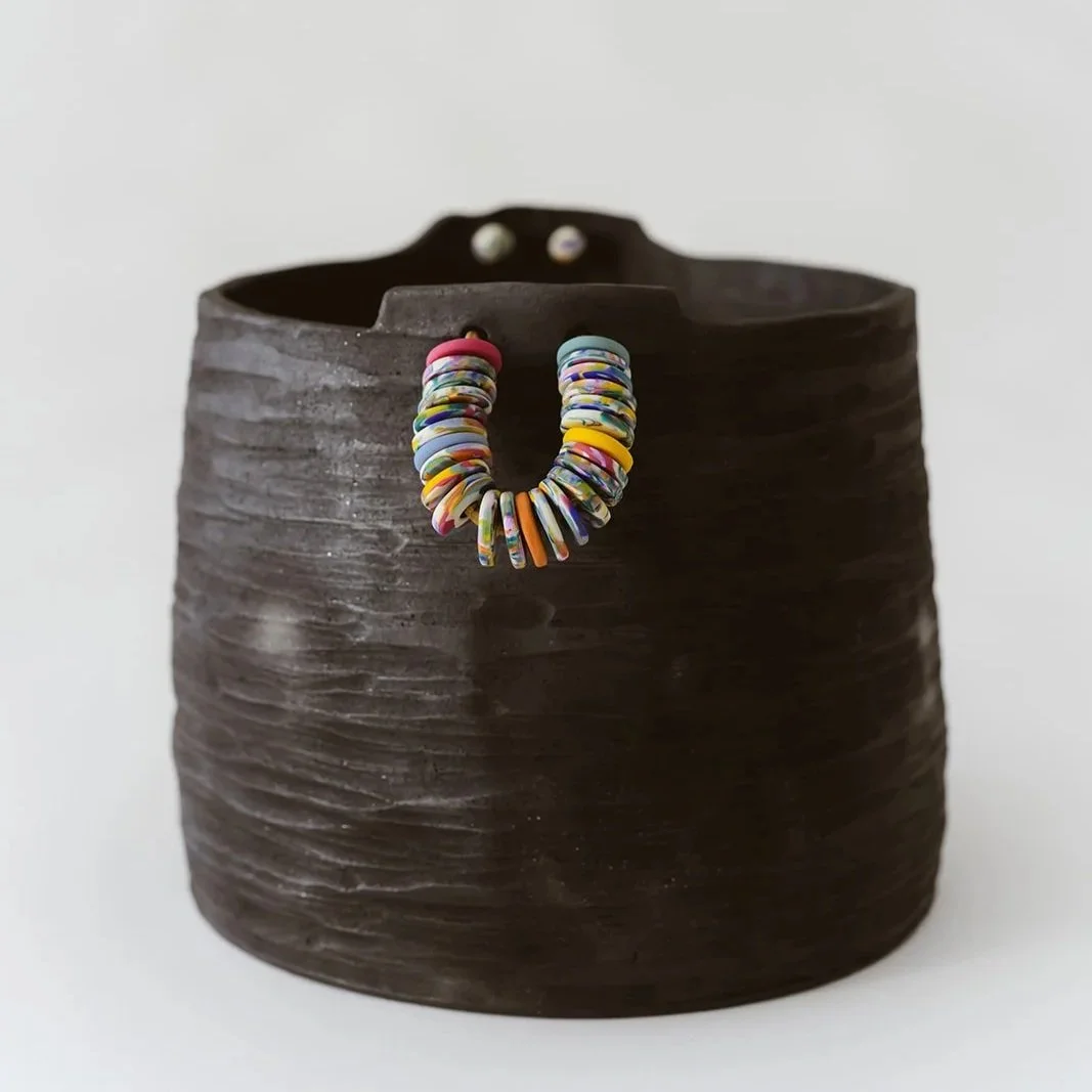 Noir handmade black pottery vase with textured finish and vibrant colorful rings