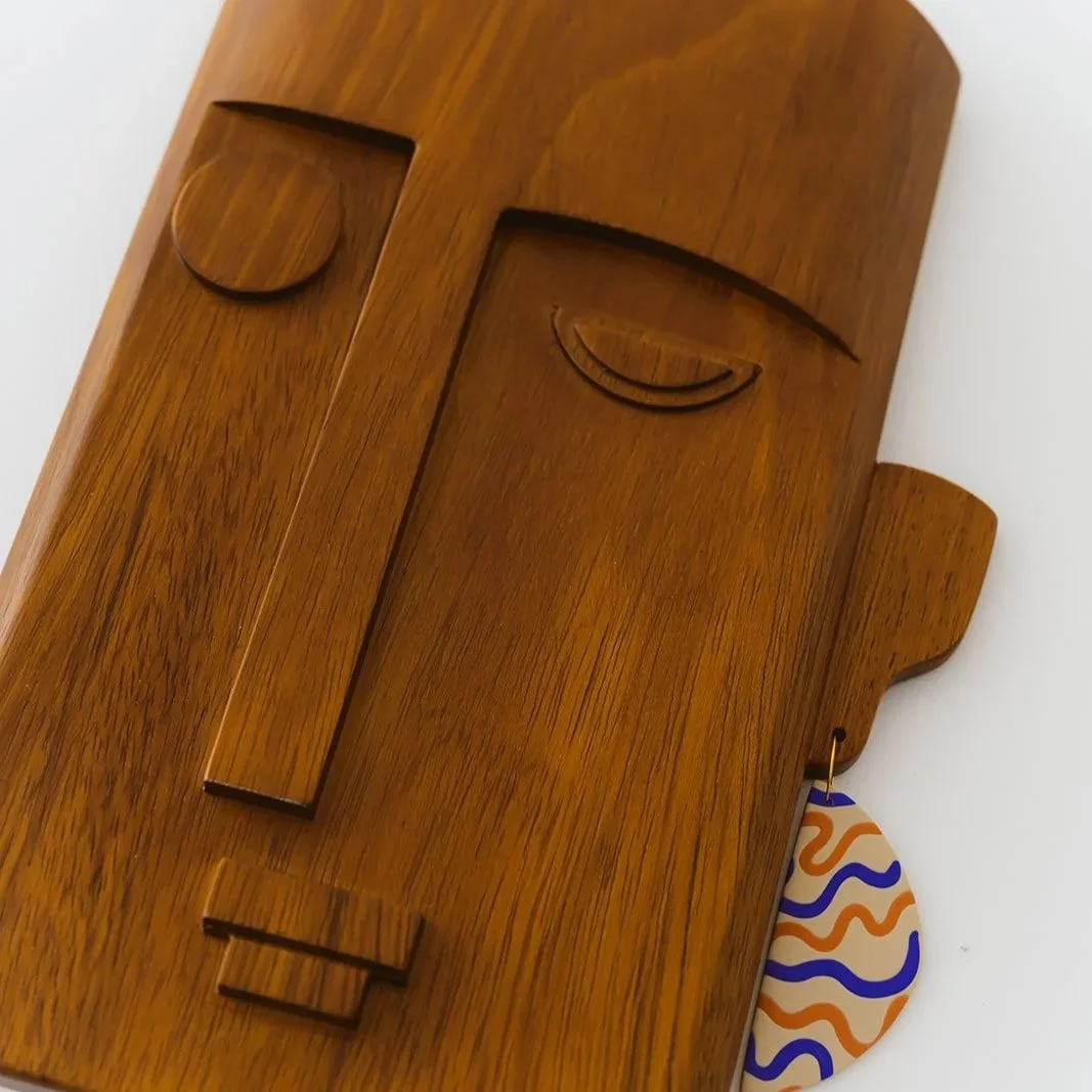Zaira hand-carved Kambala wood mask featuring a unique single earring and minimalist facial features