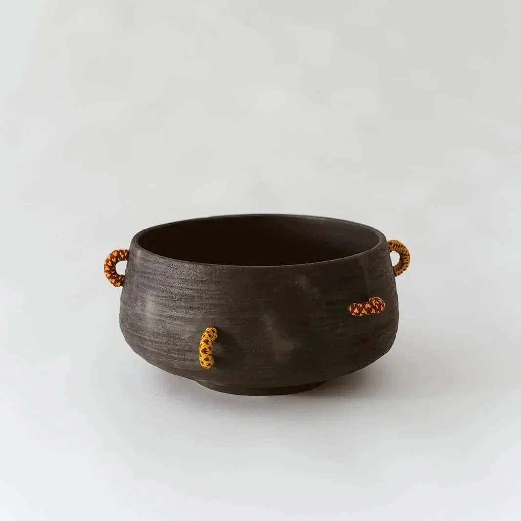 Echo handmade black pottery decorative bowl featuring intricate hand-woven fiber detailing and organic texture