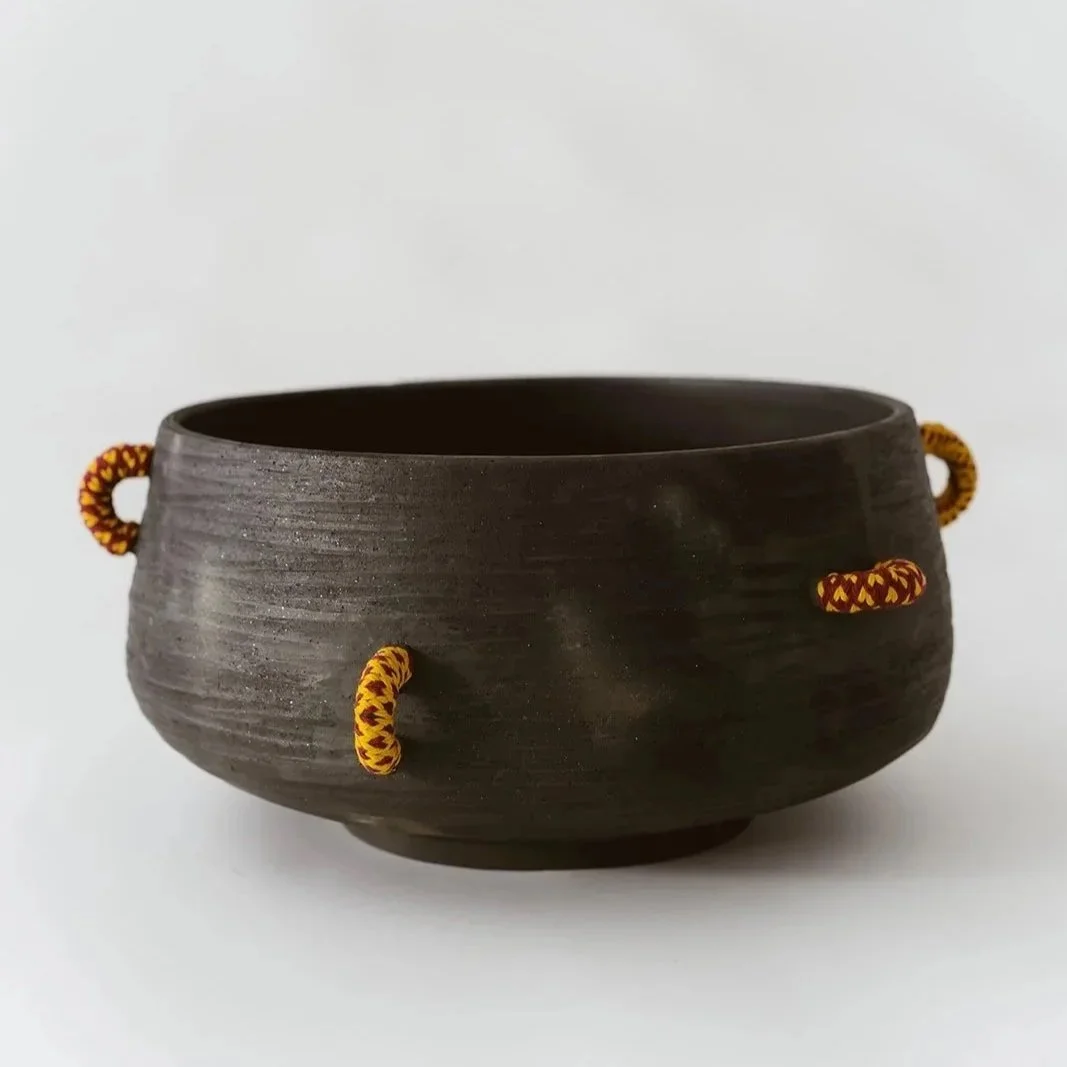 Echo handmade black pottery decorative bowl featuring intricate hand-woven fiber detailing and organic texture