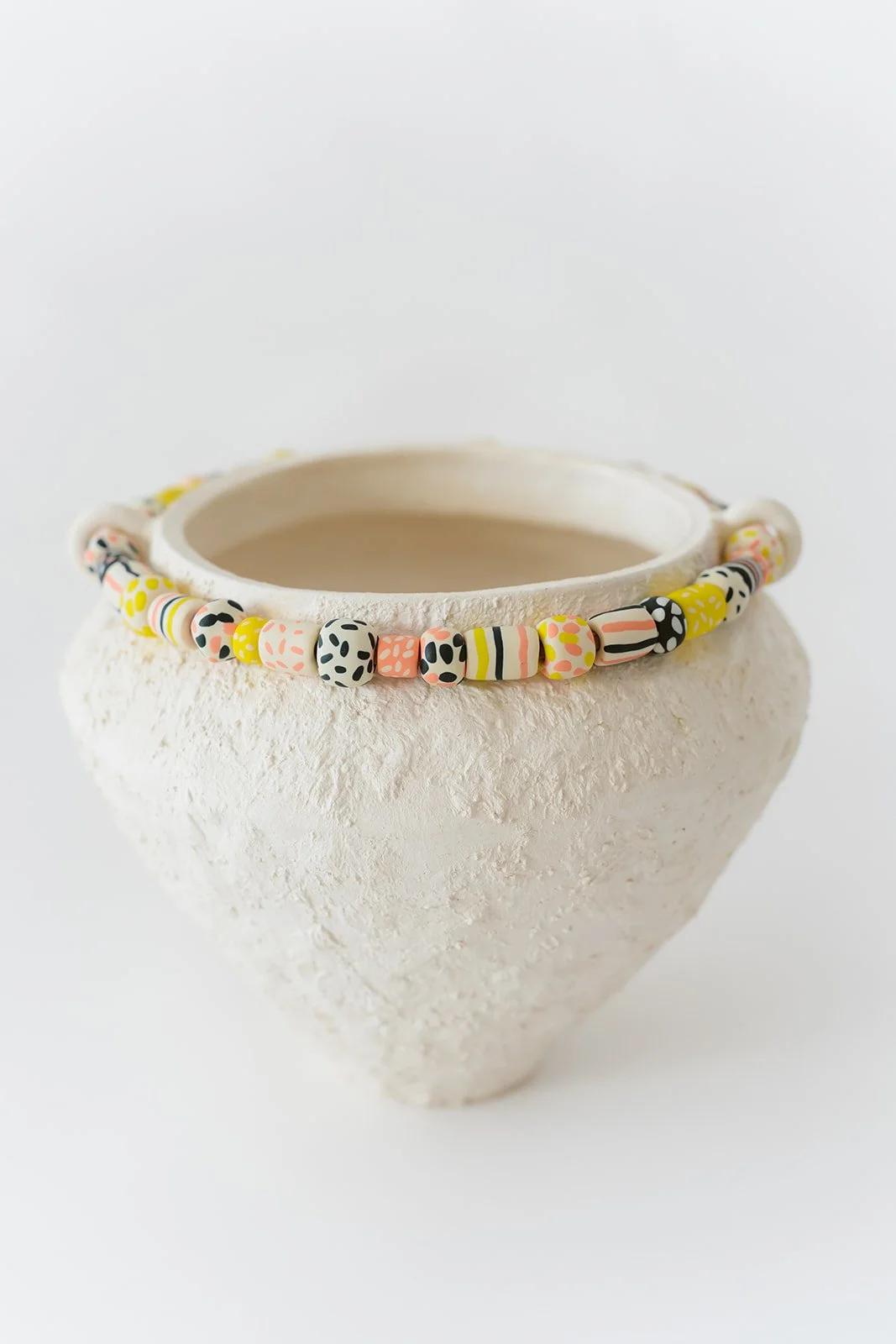 Fusion handmade white ceramic vase with grainy texture and colorful sculpted clay accents