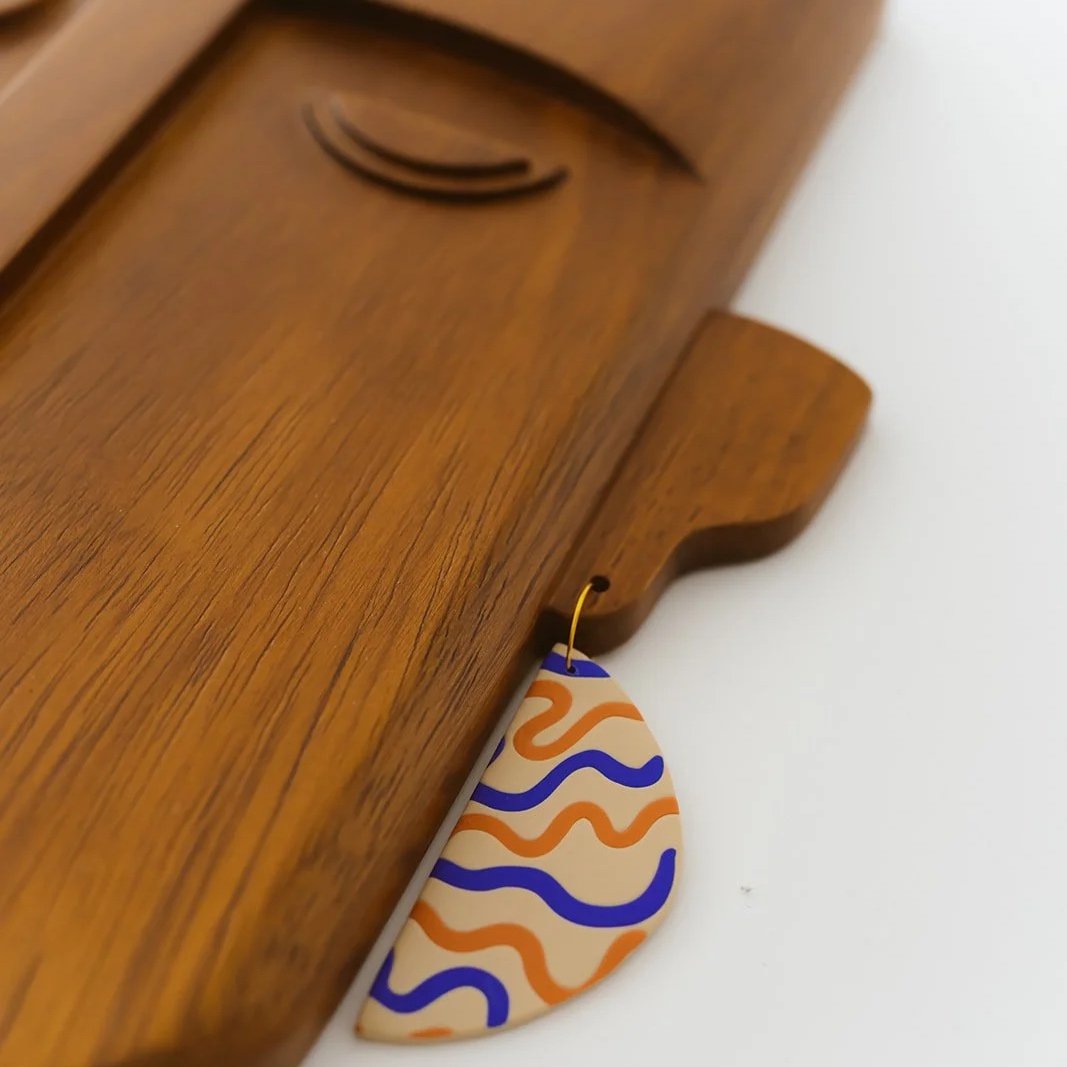 Zaira hand-carved Kambala wood mask featuring a unique single earring and minimalist facial features