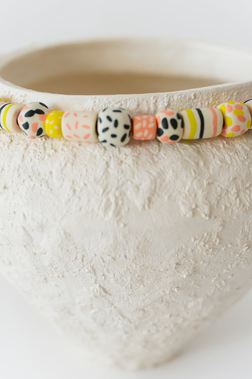 Fusion handmade white ceramic vase with grainy texture and colorful sculpted clay accents