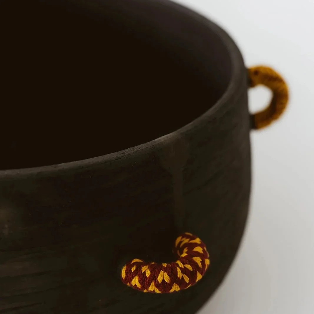 Echo handmade black pottery decorative bowl featuring intricate hand-woven fiber detailing and organic texture