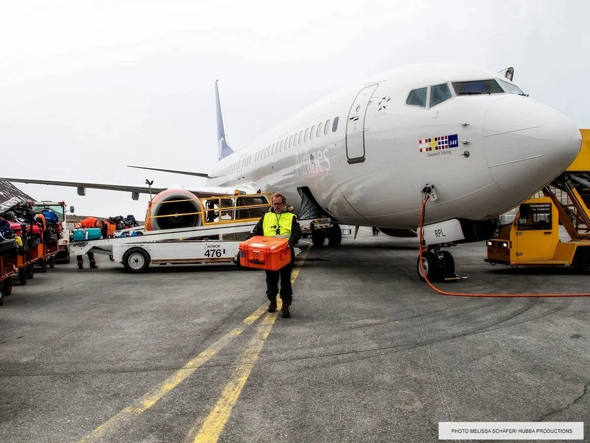 Explorer-koffert i bruk under bakketjenester ved SAS-fly med bagasjetraller.