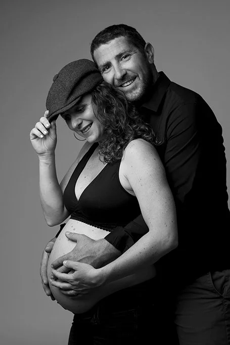 Un couple souriant, une femme enceinte dans un studio de photographe à Nantes