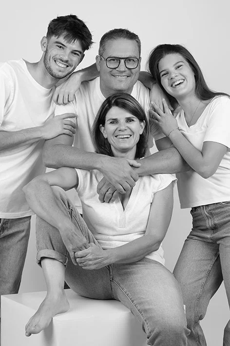 Une famille de cinq personnes souriantes posant dans un studio photo à Treillieres, près de Nantes