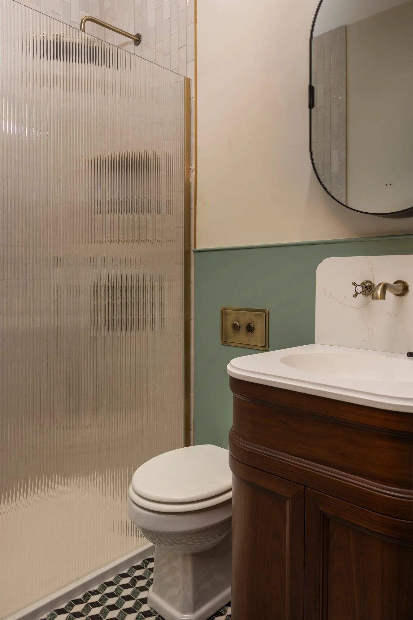 Small bathroom featuring a toilet, a wooden vanity with a marble countertop, a round mirror, and a textured folding door