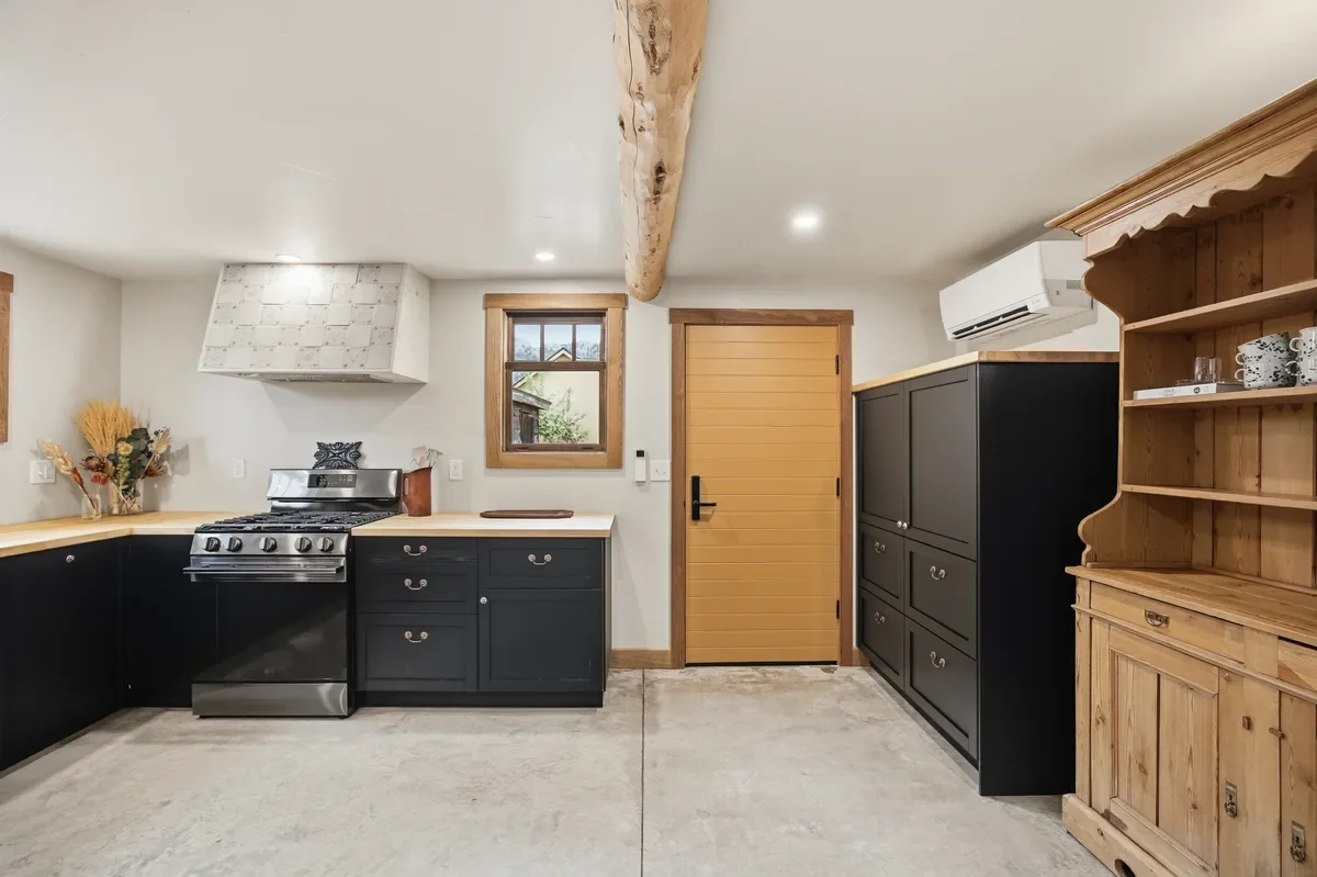 hey-house-kitchen-black-cabinets-butcher-block-range-1200w.webp