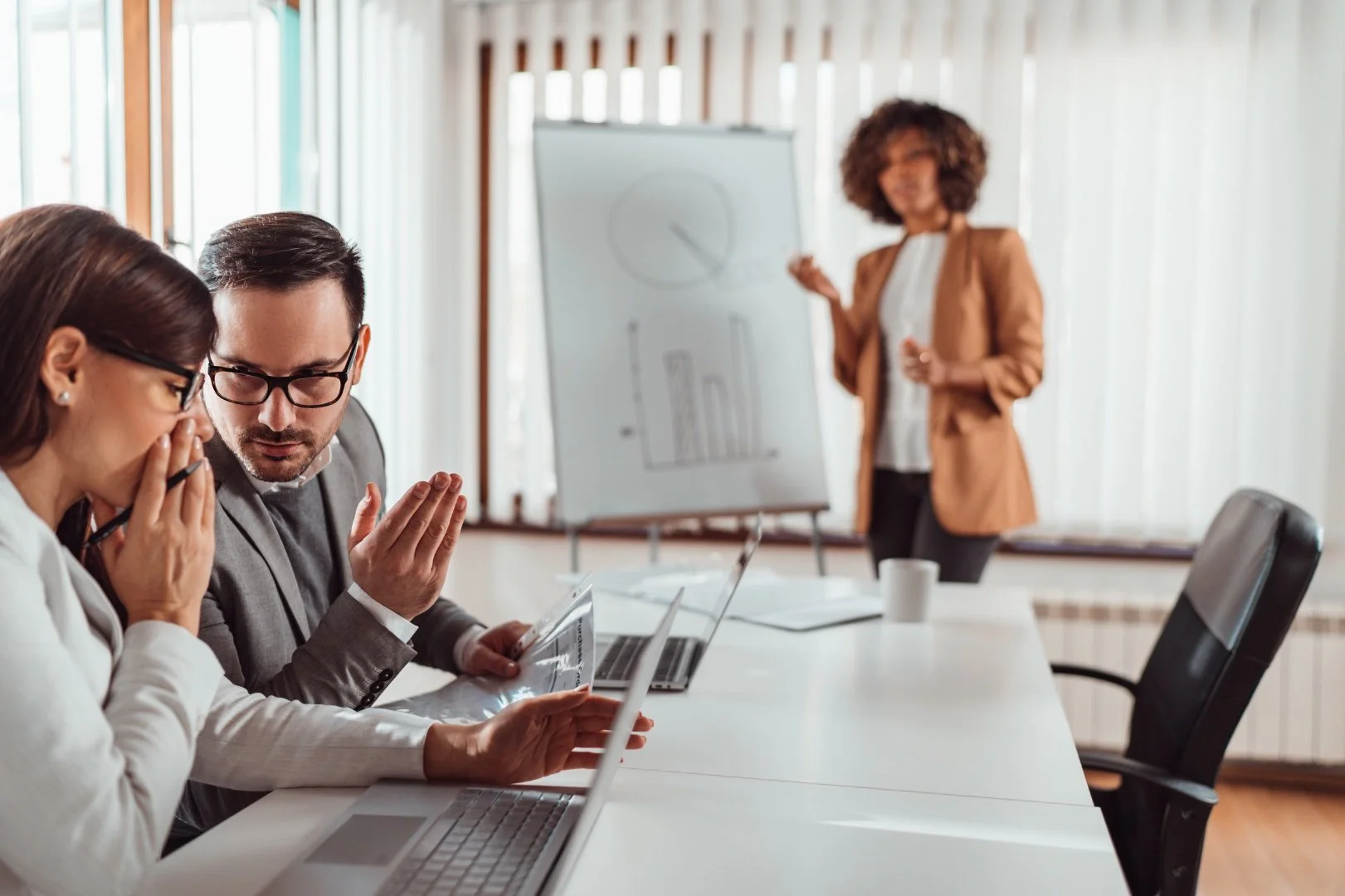 Two accountants discussing a financial report together in their company's office.