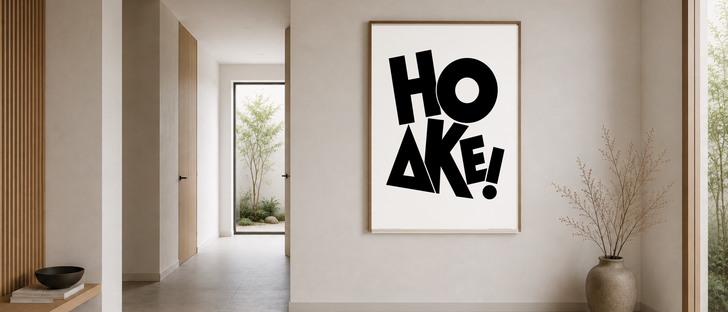 Interior hallway of a modern home with a large framed artwork that says 'HOAKE!' in bold black letters, next to a decorative potted plant, with natural light coming from a door leading to an outdoor garden.