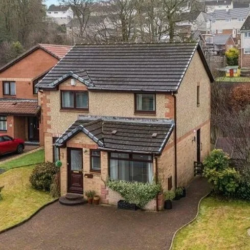 Scenic view of a lake surrounded by hills and mountains under an overcast sky.