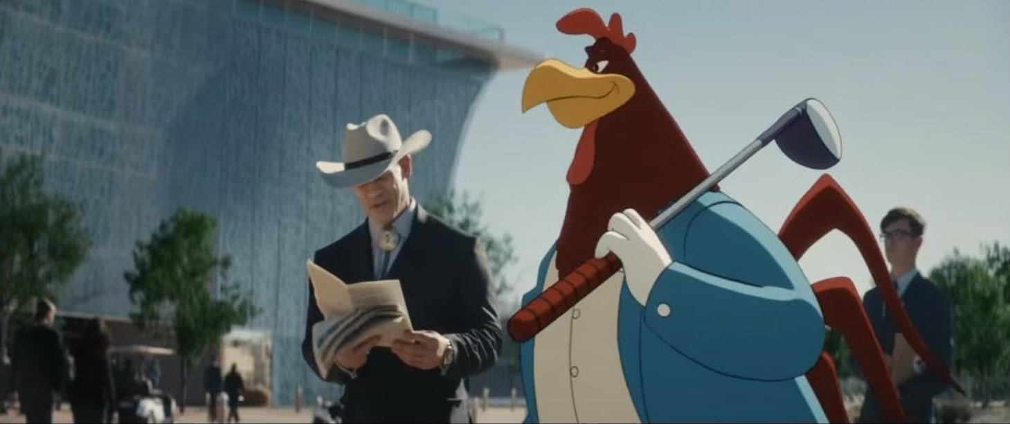 A cartoon Foghorn Leghorn dressed in a blue suit holding a golf club walking past a man in a suit and cowboy hat (John Cena) reading a newspaper outside, with modern buildings and people in the background. Still from Coyote vs Acme 2026