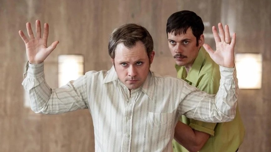 Film still from Dead Man's Wire (2025) starring Bill Skarsgård and Dacre Montgomery, who are playing hostage taker and hostage.
