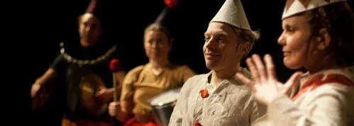 En grupp personer i teaterkostymer under en föreställning