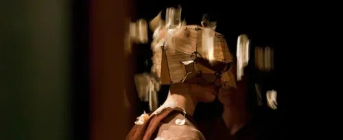 En person som dansar eller poserar i en mörk miljö med bokeh-effekt i bakgrunden.