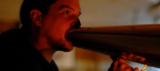 Man som dricker ur ett långt rör eller snorkel.