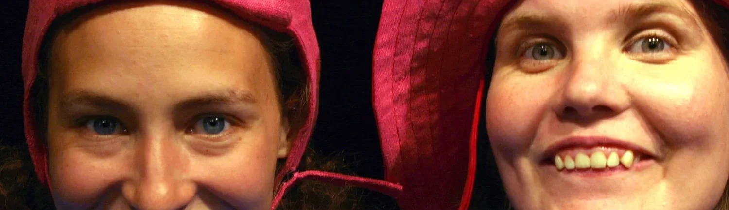 Två personer med hjälmar, en pojke och en man, båda med leenden, nära varandra.