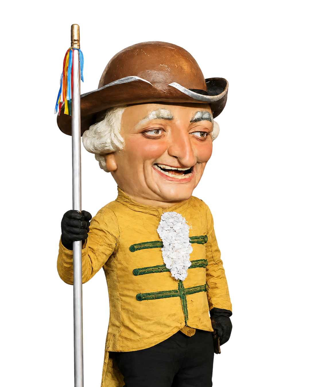 Muñeco con rostro de anciano, vestido de uniforme militar amarillo con detalles verdes, lleva sombrero de piel de animal y sostiene una bandera con flecos de colores.