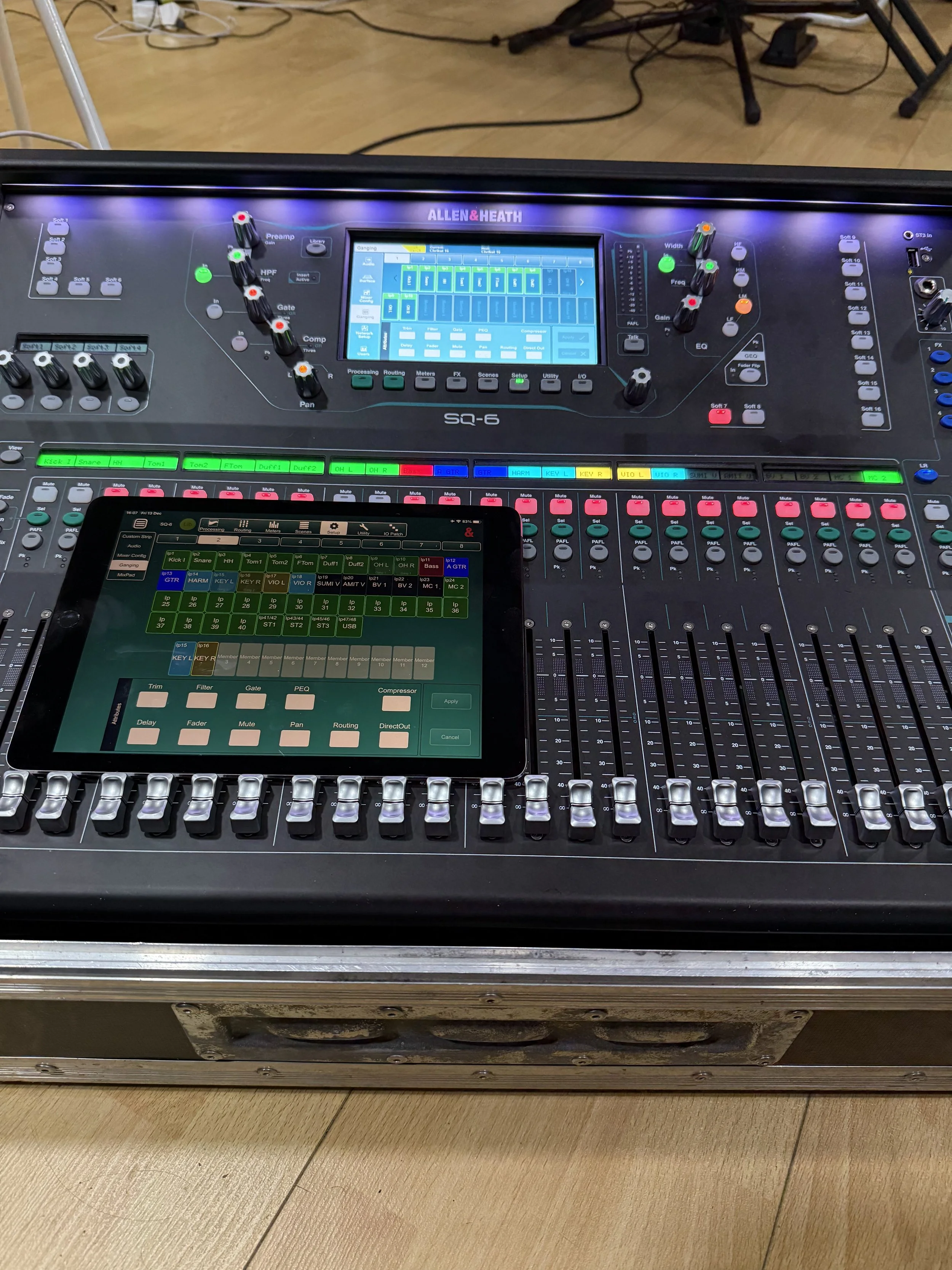 A professional audio mixing console with various controls, knobs, sliders, and a touchscreen display used for sound engineering and live event management.