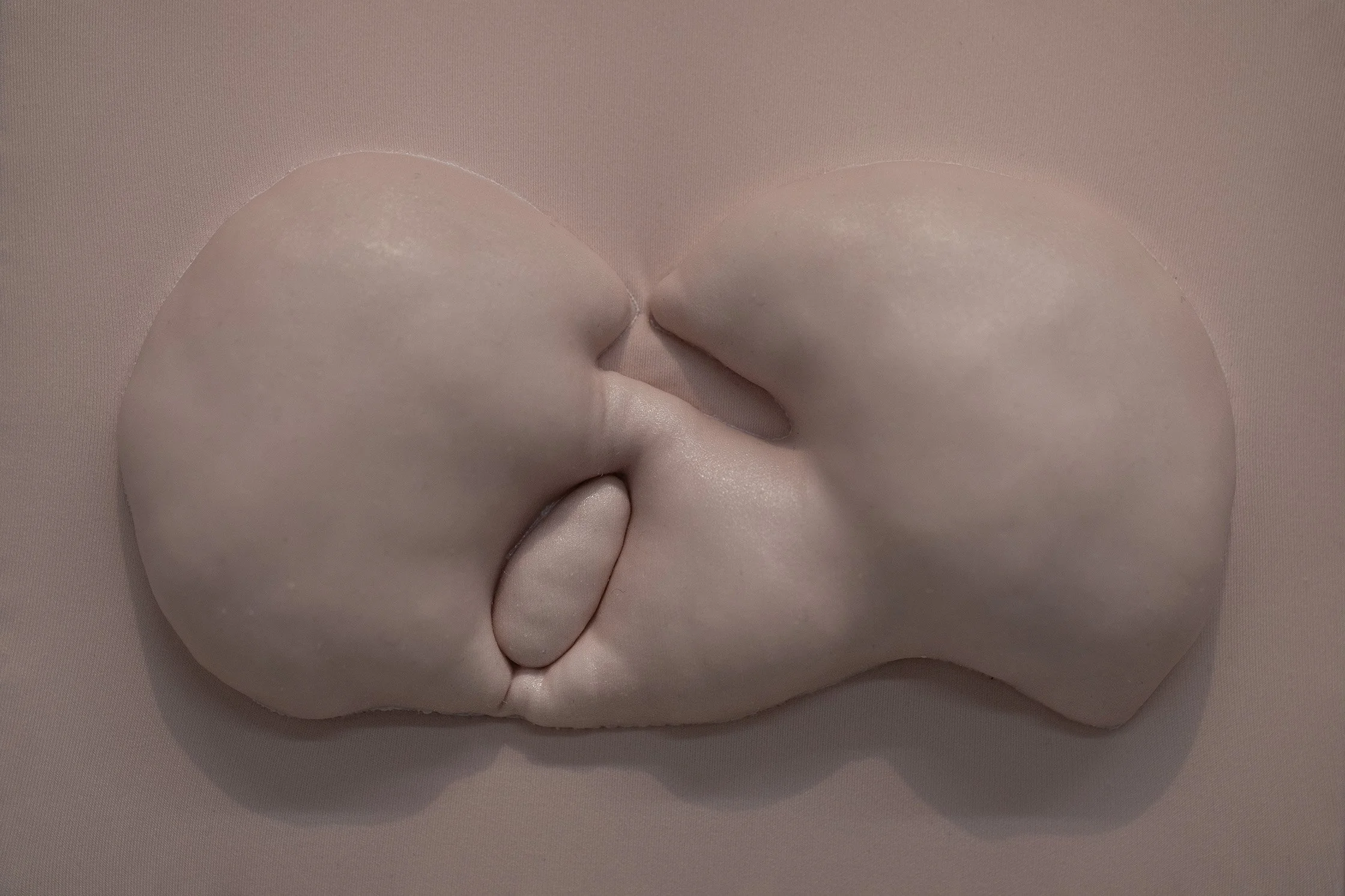 Nahaufnahme eines Paares, das sich hautnah küsst, mit Fokus auf ihre Gesichter und Lippen, vor einem einfarbigen Hintergrund.
