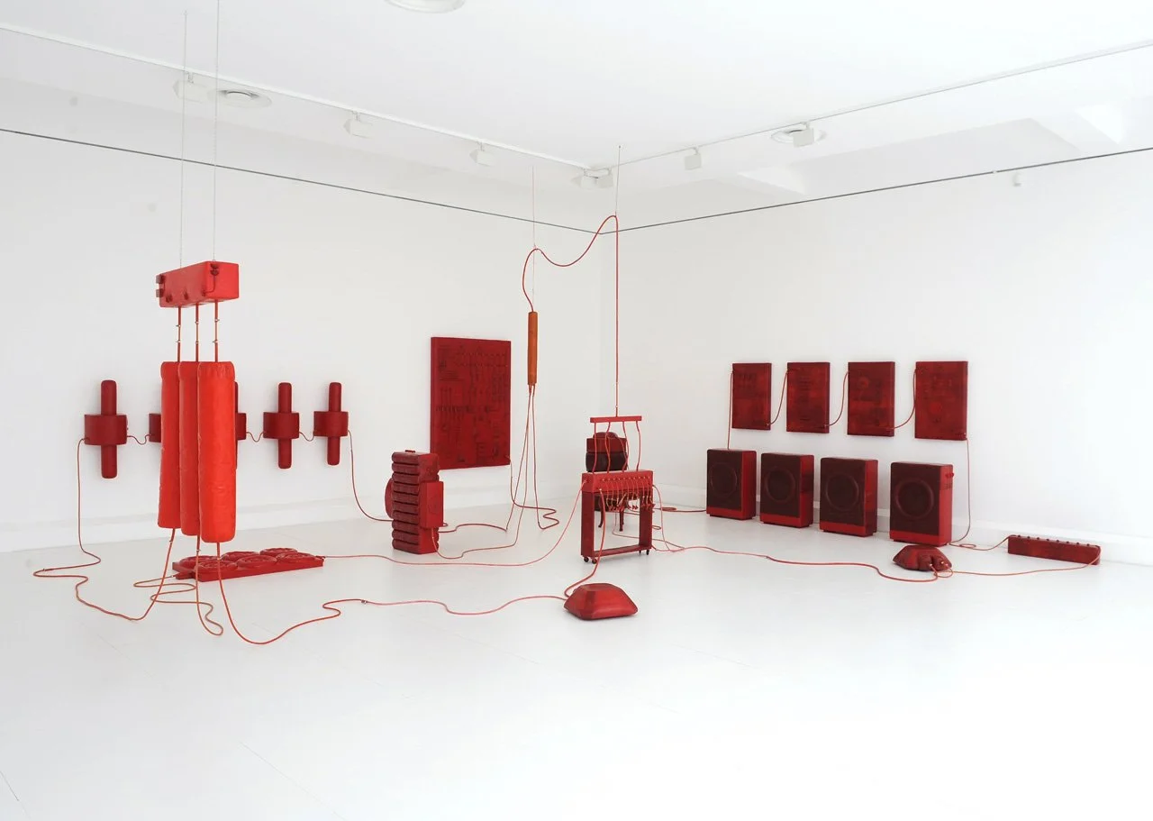 Installation mit roter elektrischer Geräte, Lautsprecher und Kabel in einem weißen Raum.