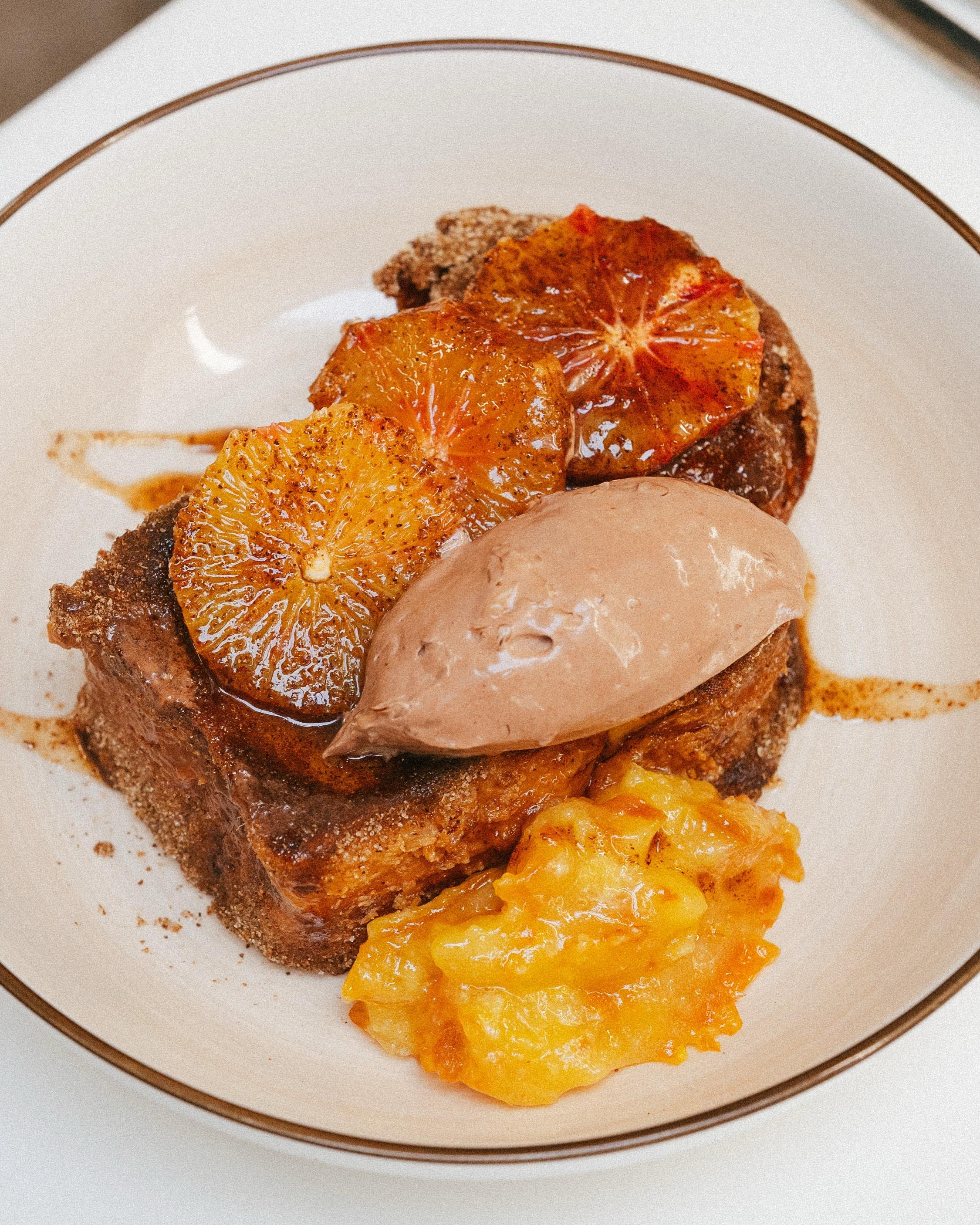 Plat de restaurant gastronomique, pain perdu aux agrumes et glace au chocolat