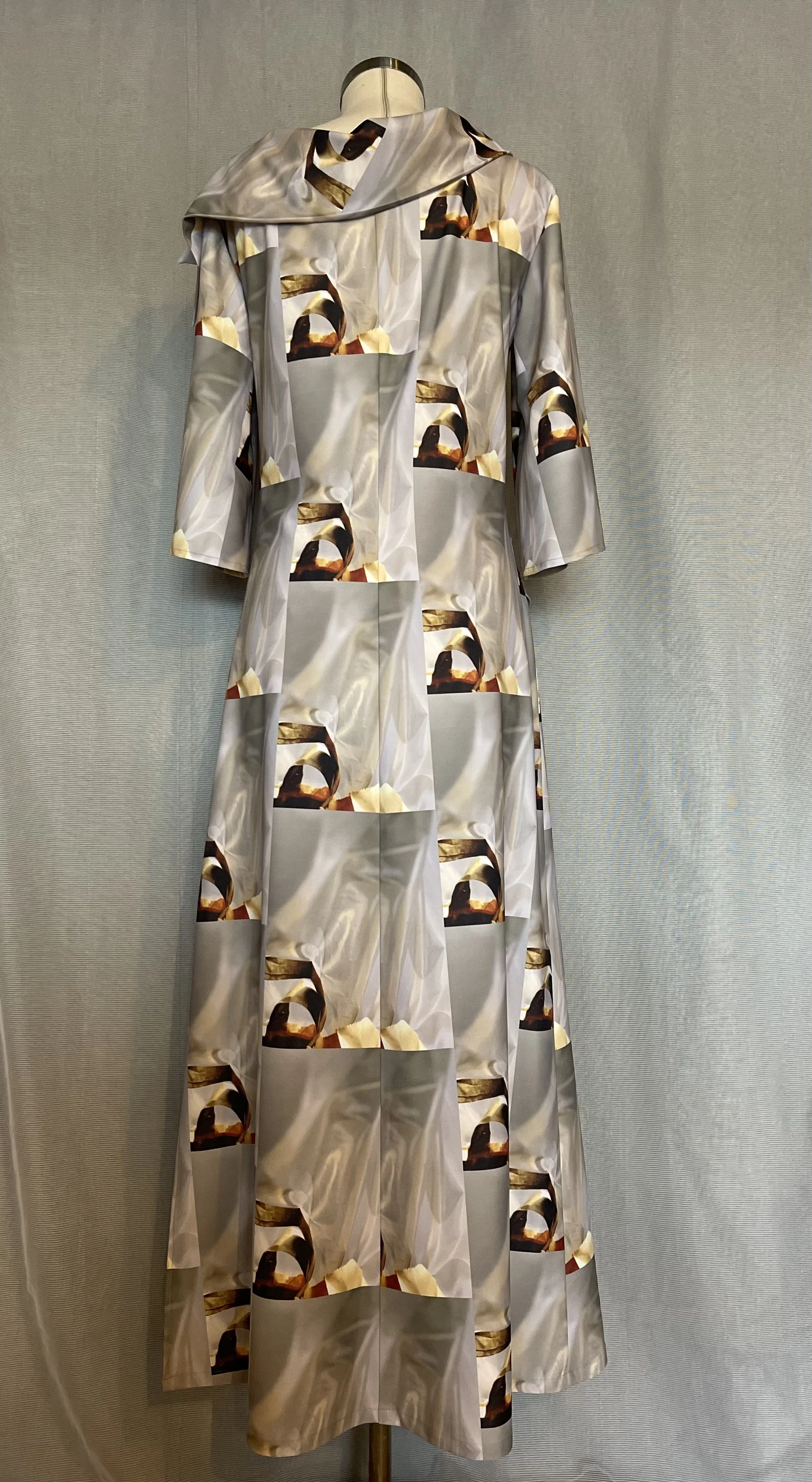 Long dress displayed on a mannequin with abstract patterned fabric in light shades, featuring images of desserts or pastries
