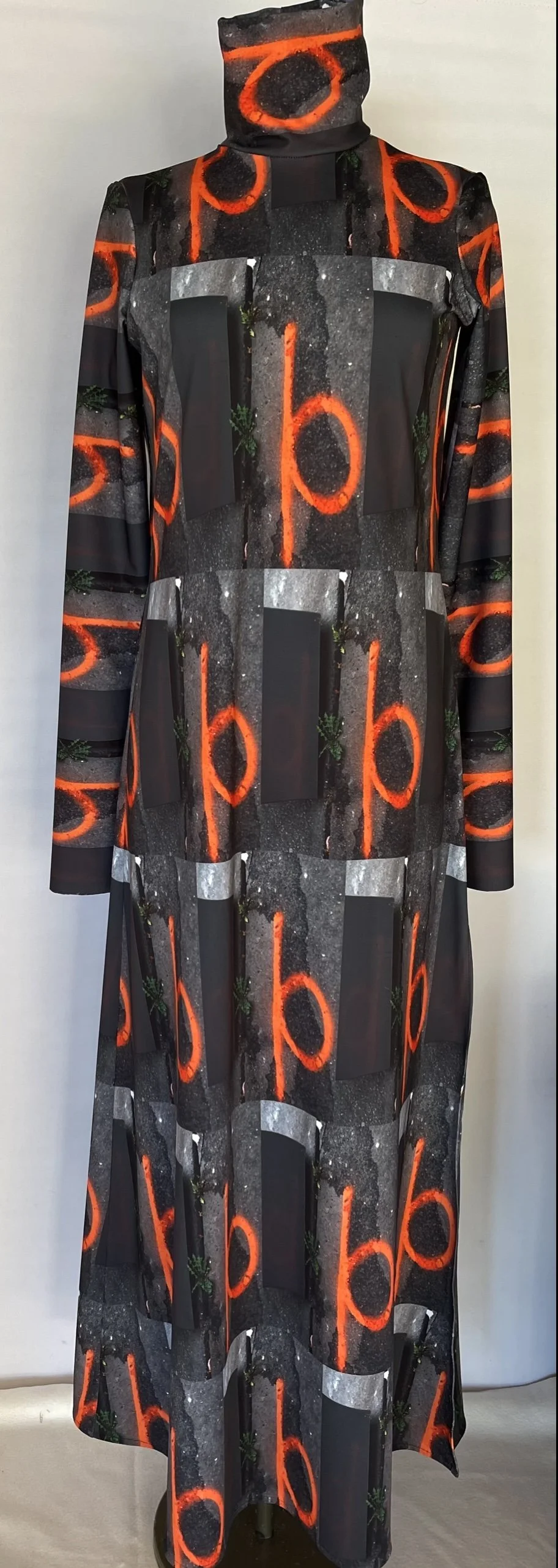 A long dress with a high neck featuring a pattern of abstract black, gray, and orange designs resembling neon circled symbols and geometric shapes.