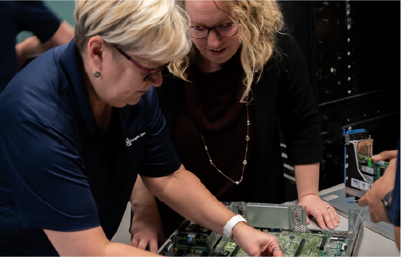 two women looking at computer server equiptment