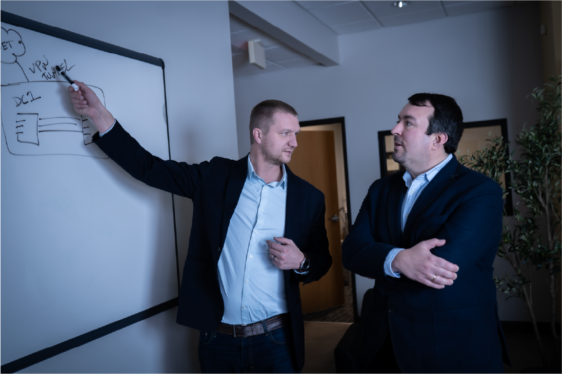 Two men looking at a whiteboard