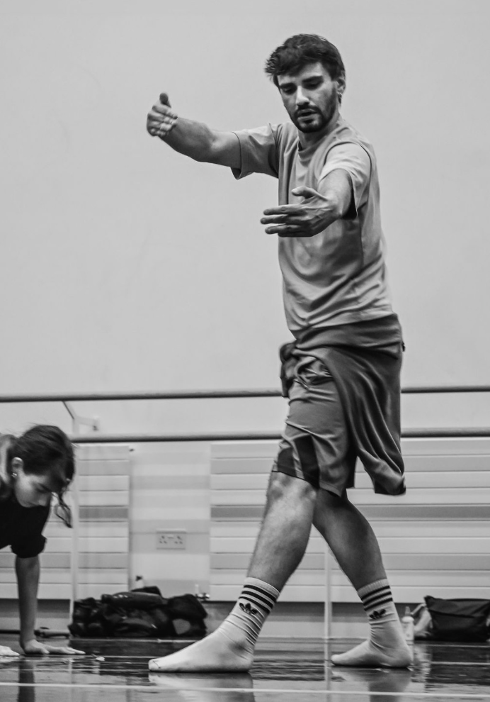 Black and White image of Aaron Markwell dancing at Rambert's The Playground, with outstretched arms. Photography by Cath Duput