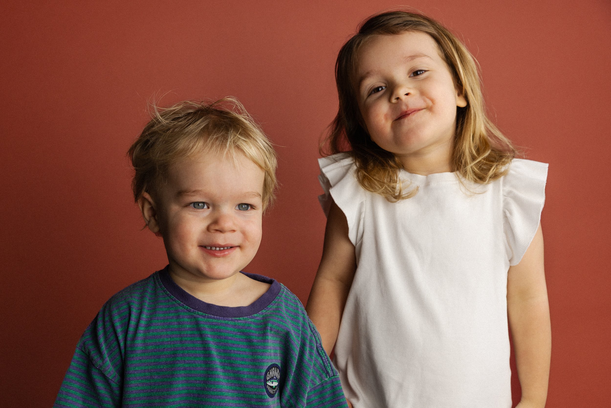 Broer en zus foto op rode achtergrond door Studio Oogappel