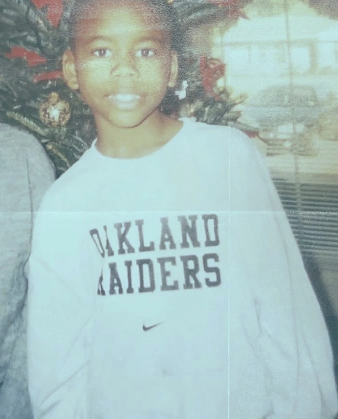 Childhood photo of DaQuan Bethea wearing an Oakland Raiders sweatshirt.