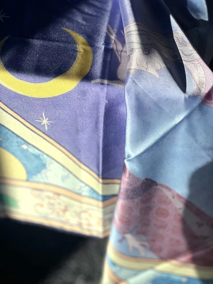 Silk scarf printed with the illustration, extending the artwork into a wearable format.