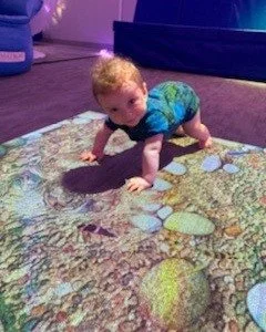 baby crawling on floor looking up at the.jpg
