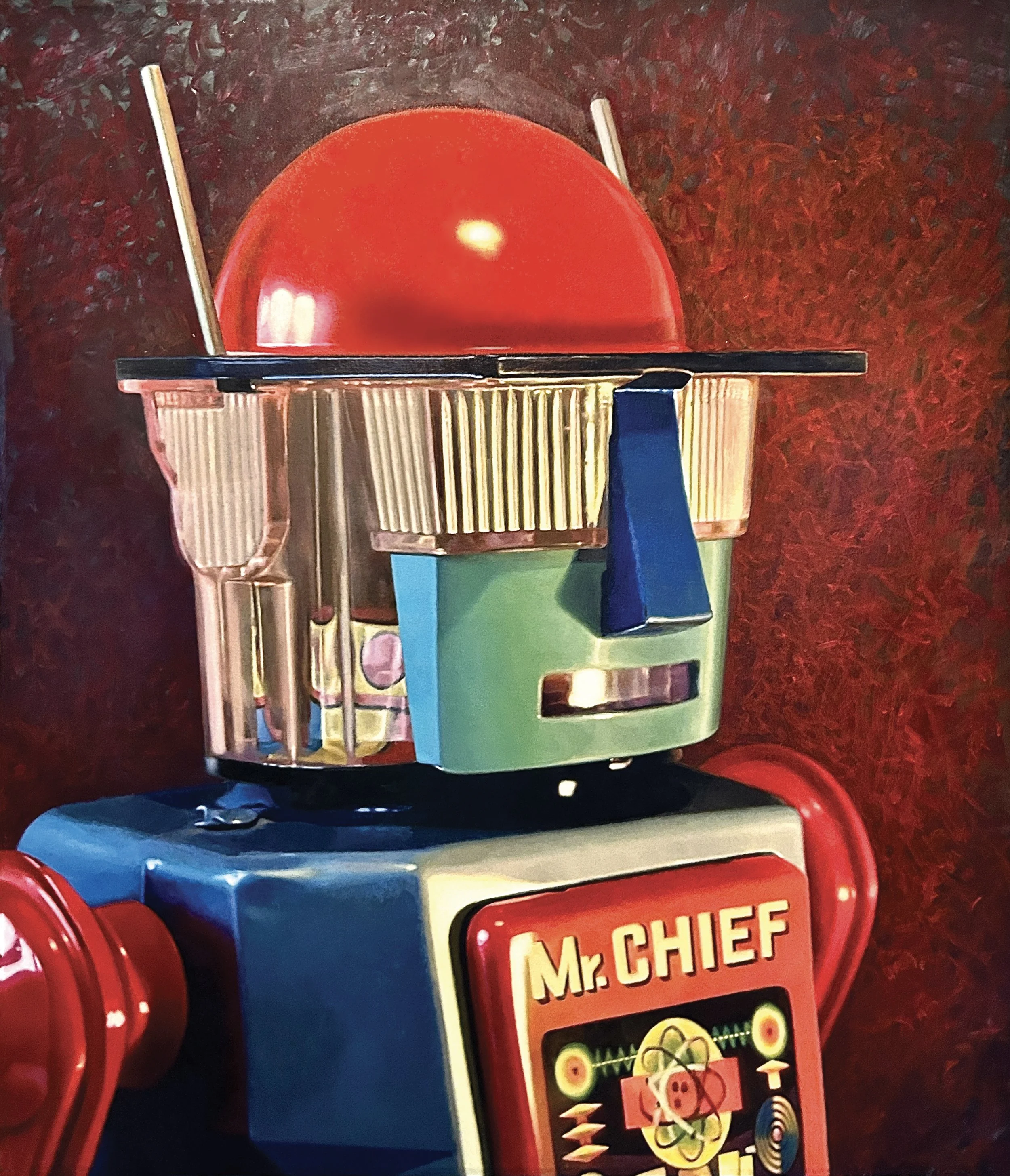 Toy train with a red cabin and a green and blue body, featuring a Mr. Chief license plate on the front.