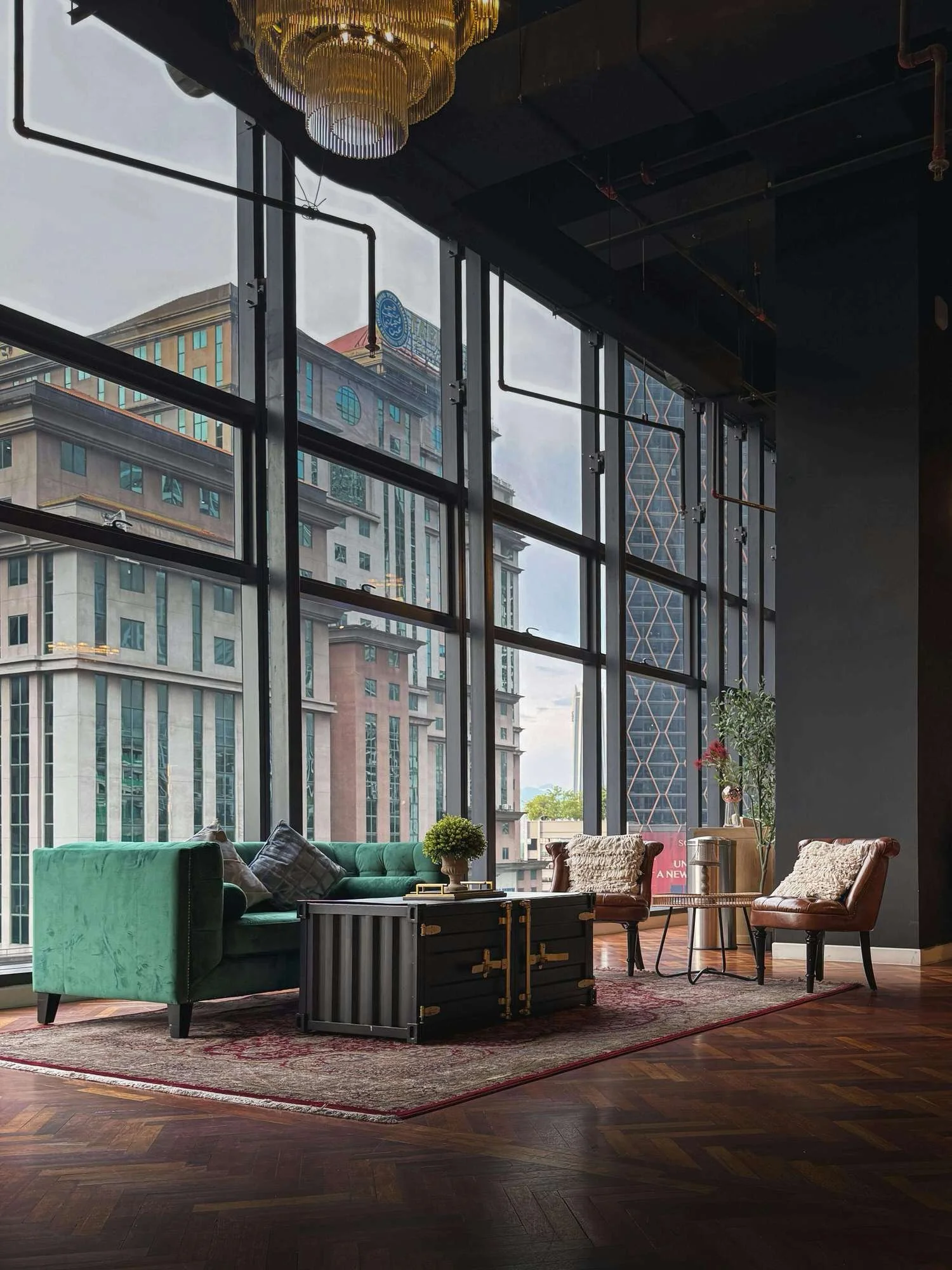 Owners Representative Services - interior design of room with green courch coffee table and chairs and floor to ceiling windows overlooking the city