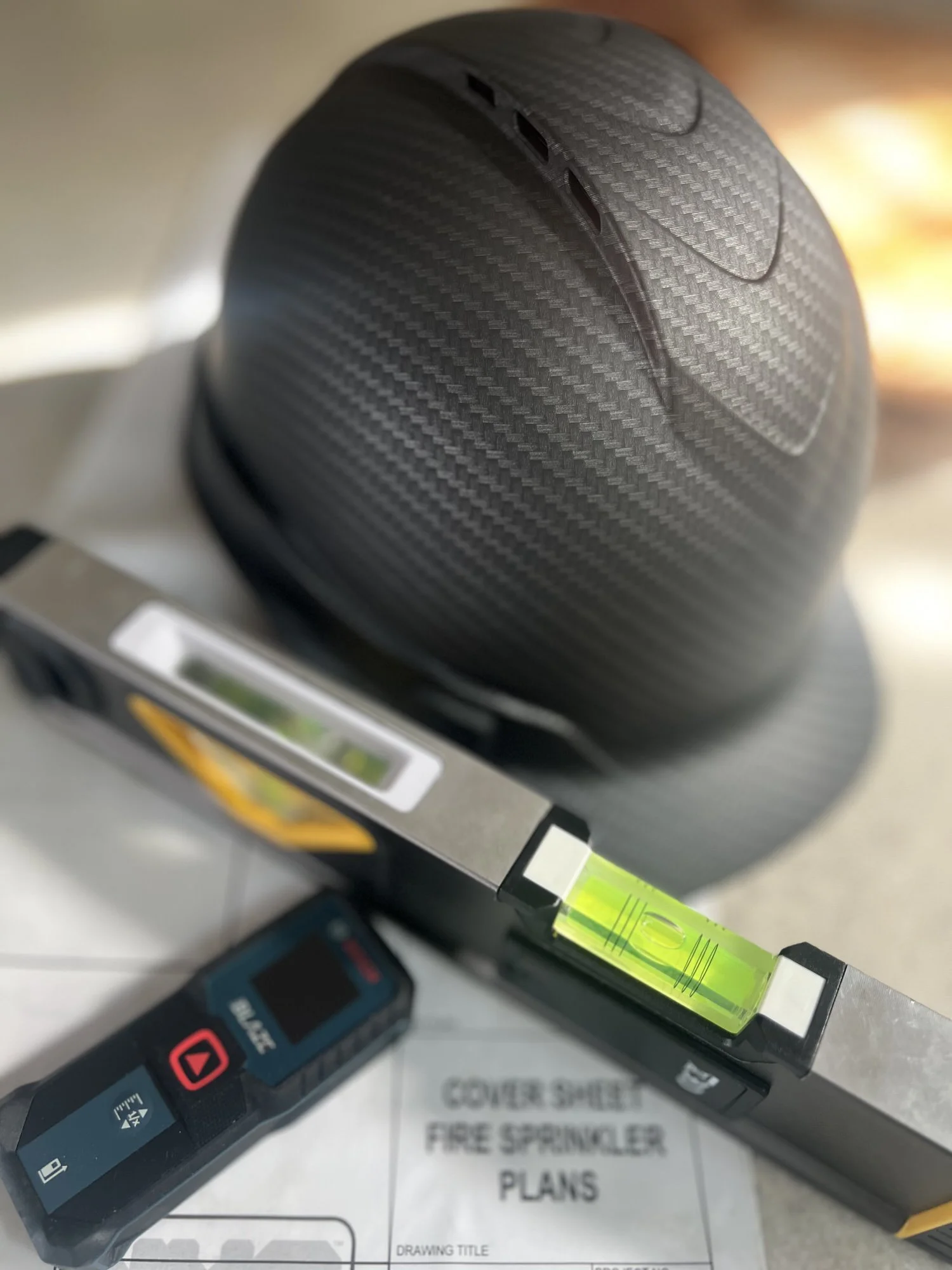 black hardhat, construction tools, and project management plans