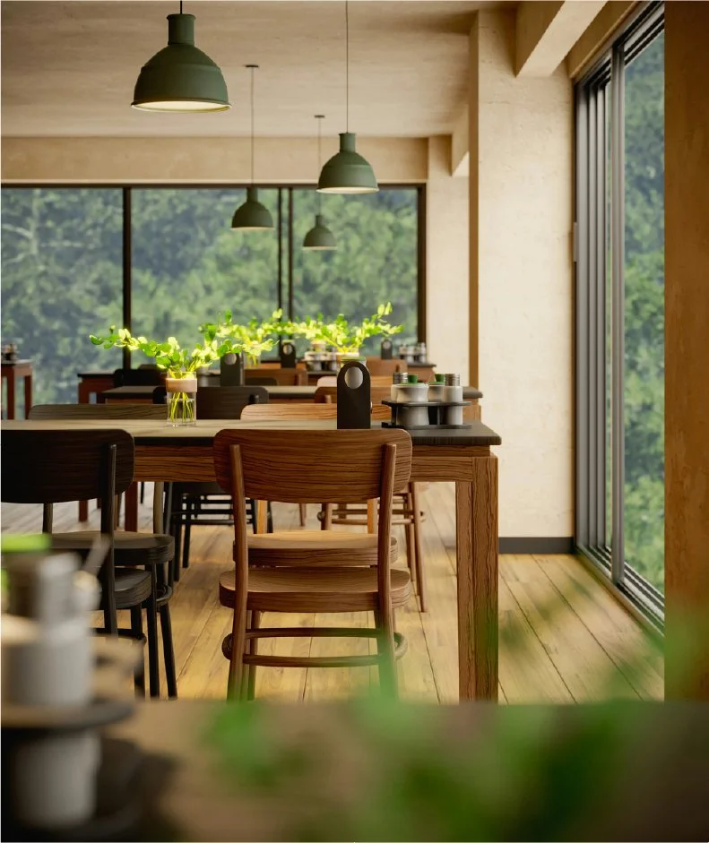 Intérieur d'un restaurant avec des tables en bois, des chaises en bois, des lampes suspendues, et une grande baie vitrée donnant sur un espace vert.