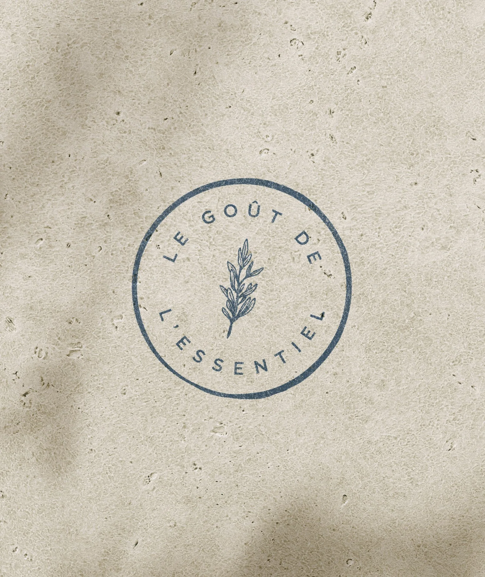 Logo encrée sur une surface en papier texturée avec la phrase "Le goût du sentiment"