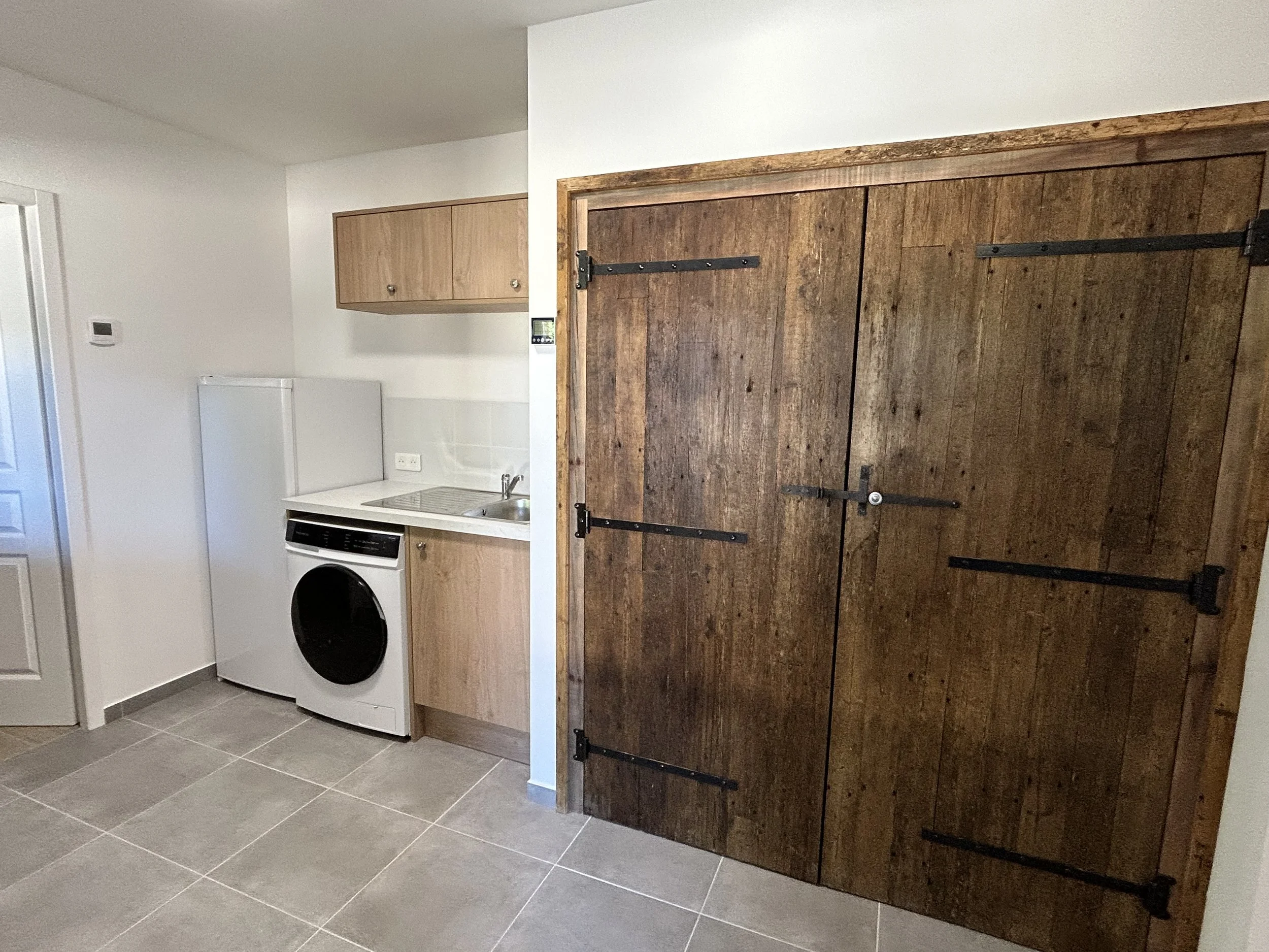 Utility room showing washing machine and fridge.jpeg