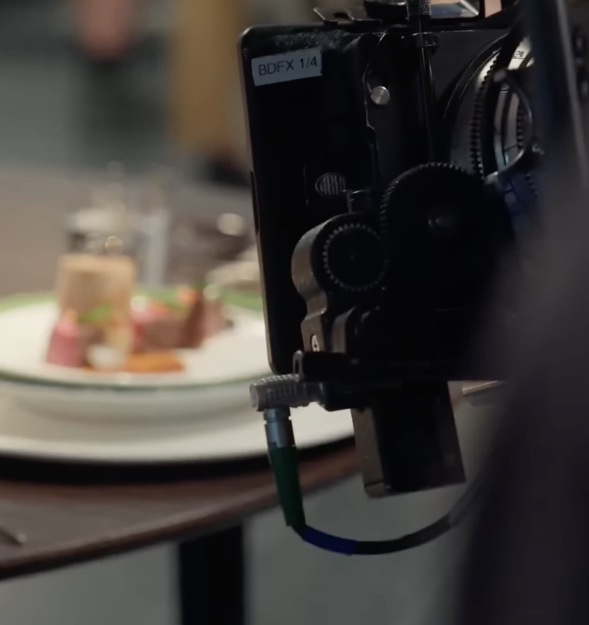 A camera set up for a food photography shoot, capturing a plated dish with what appears to be miniatures of food items on a white plate.