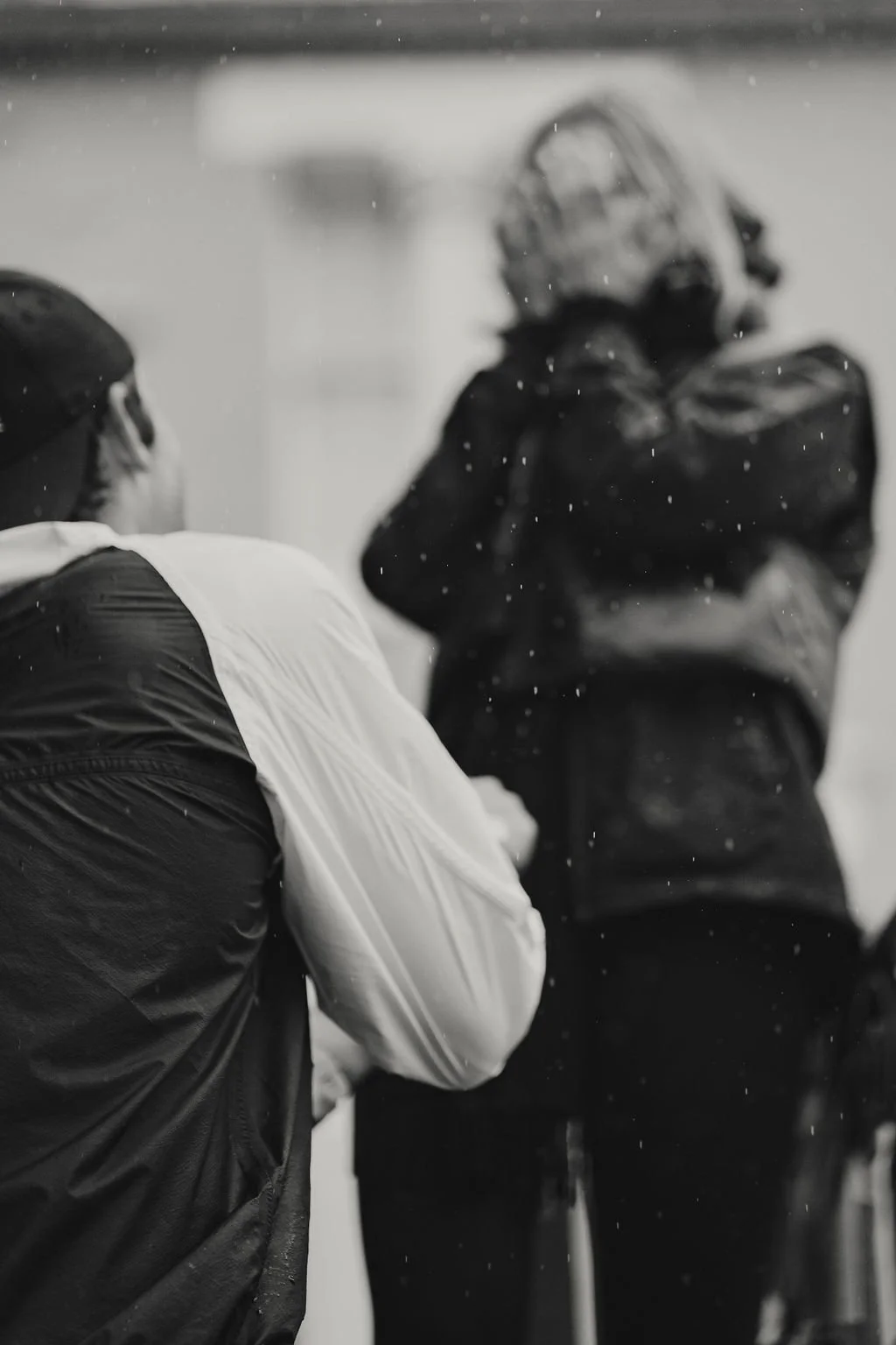 Black and white photo of two sports players in a game, one in the foreground and one in the background, with the player in the background wearing a helmet.