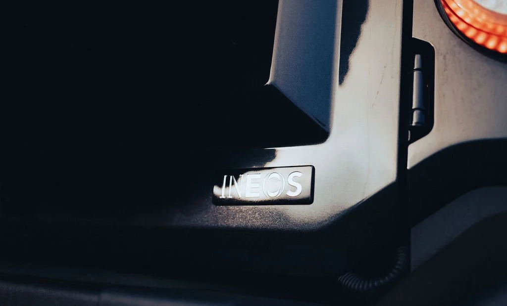 Close-up of a vehicle dashboard with an INEOS logo badge.