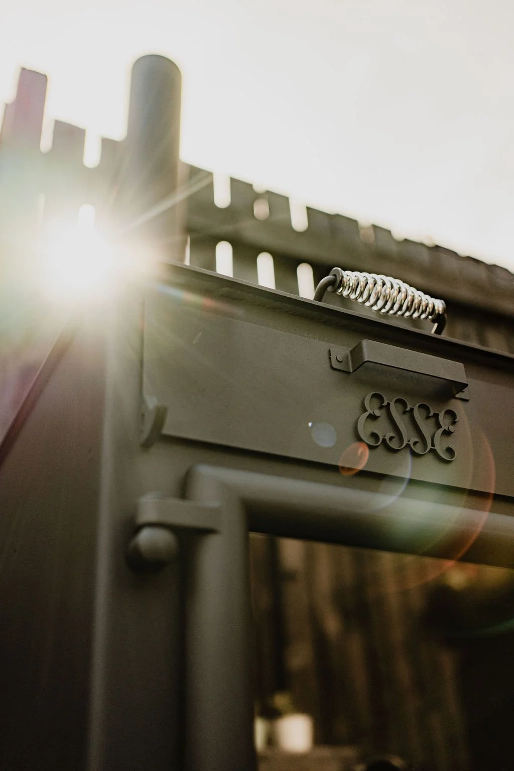 Close-up of an outdoor stove with sunlight shining from the left.