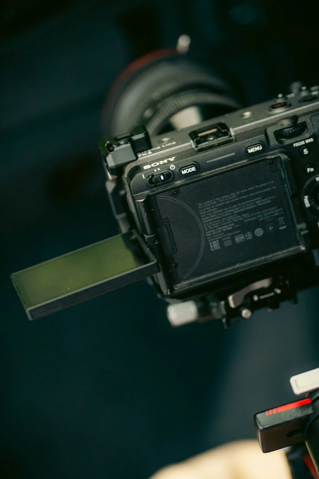 Close-up of a Sony digital camera with a tilt-out screen showing, against a dark background.